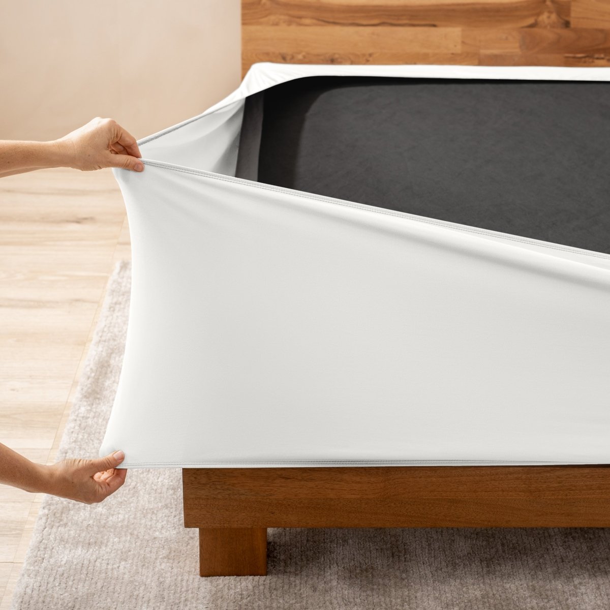 A person stretching a box spring cover