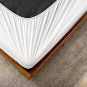 The corner of a box spring with a cover on it