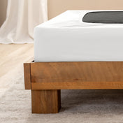 Close up of the corner of a bed frame with a cover box spring