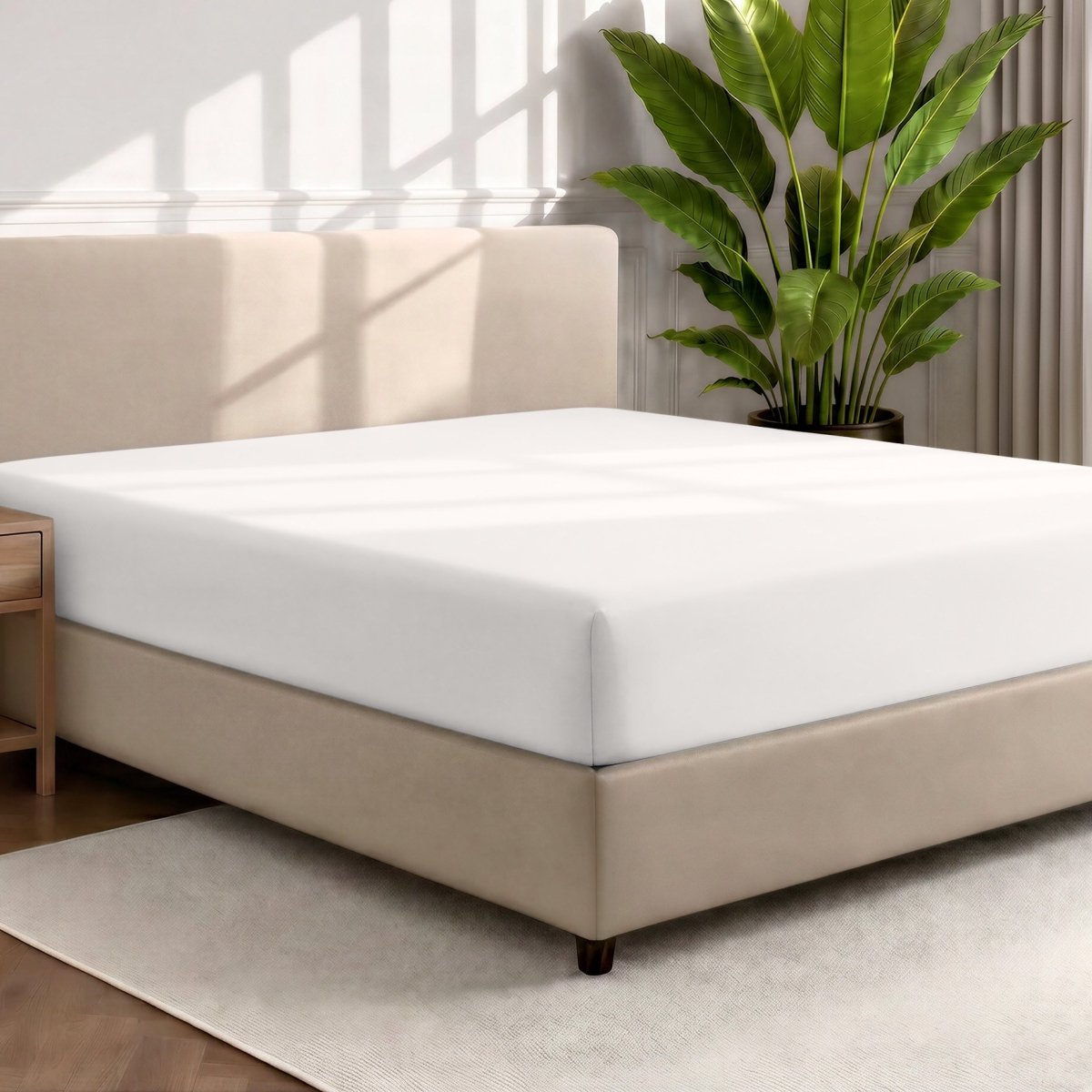 Bed with a fitted sheet in a room with a large plant and rug