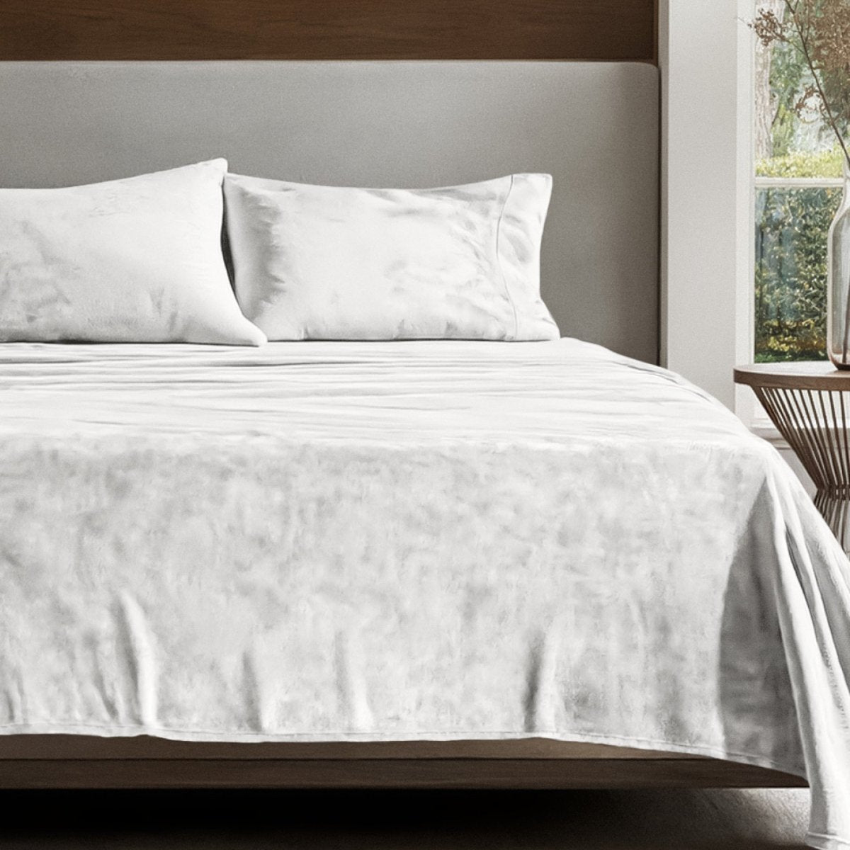 Microplush sheet set on a bed in a bedroom setting with a nightstand and lamp.
