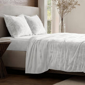 Neatly made bed in a well-lit bedroom.