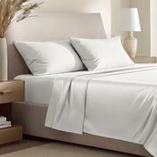 Sateen bedding set including a fitted sheet and two matching pillowcases on a bed.