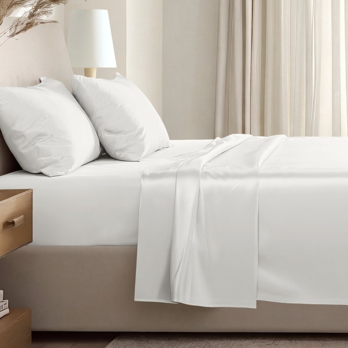 Sateen sheet set on a bed in a softly lit bedroom.