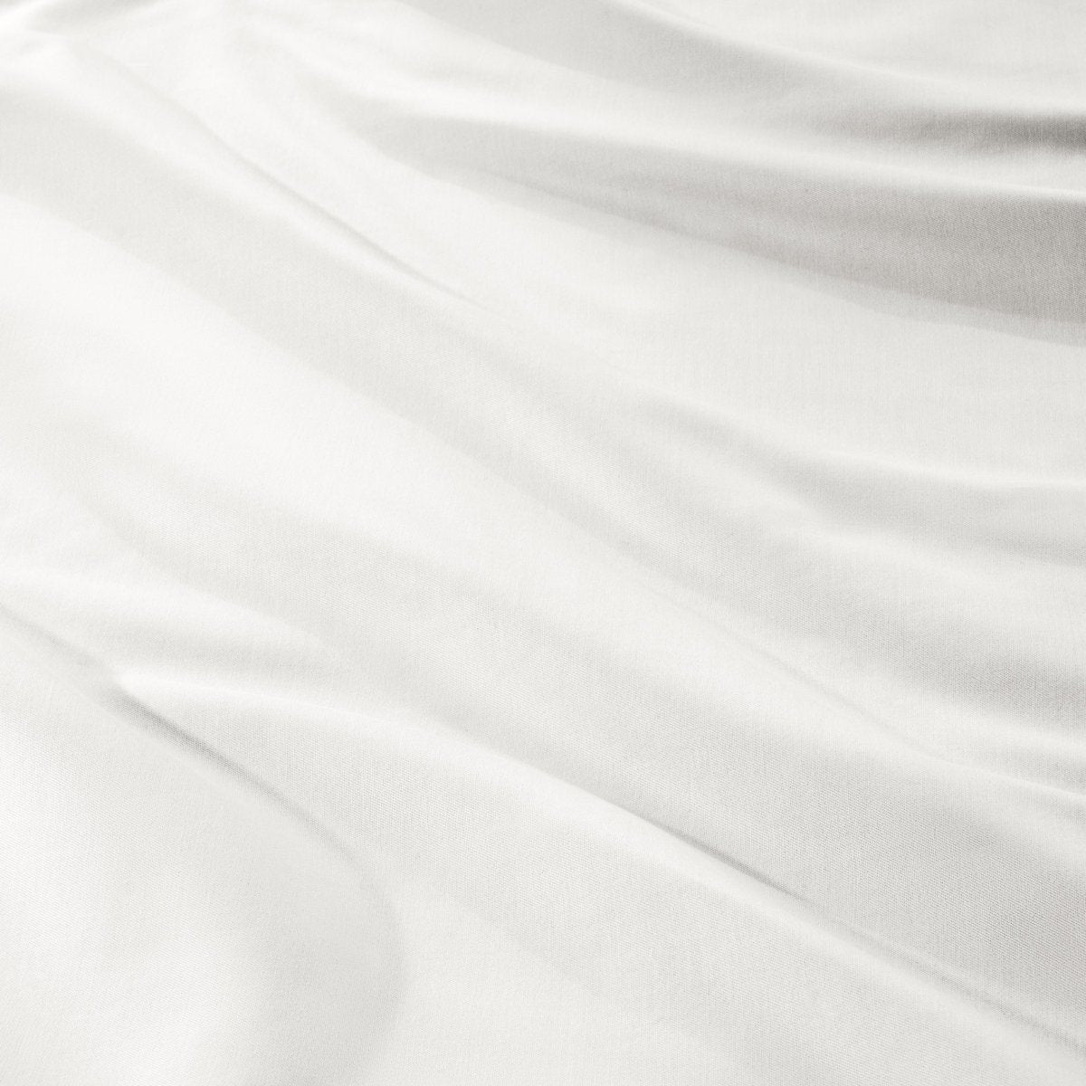 A close-up of draped sateen fabric with soft folds and a smooth texture.
