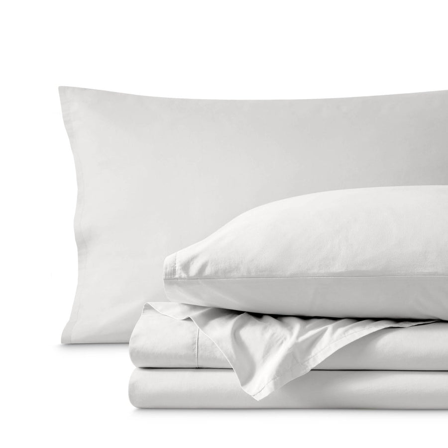 Percale bedding set including pillowcases and folded sheets arranged on a clean white background