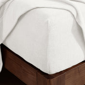Corner of a mattress with a fitted sheet on it