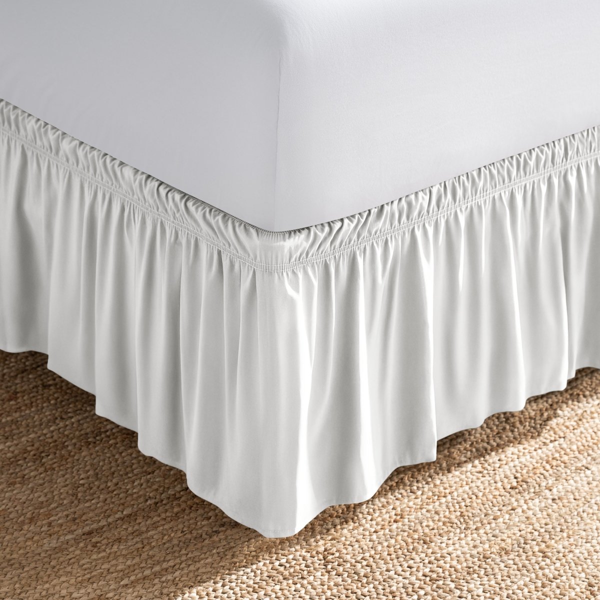 Bed with white fitted sheet and an adjustable bed skirt.
