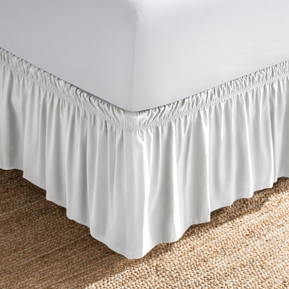 Bed with white fitted sheet and an adjustable bed skirt.