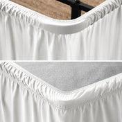 Close up of a polyester wrap around bed skirt on a bed frame and box spring