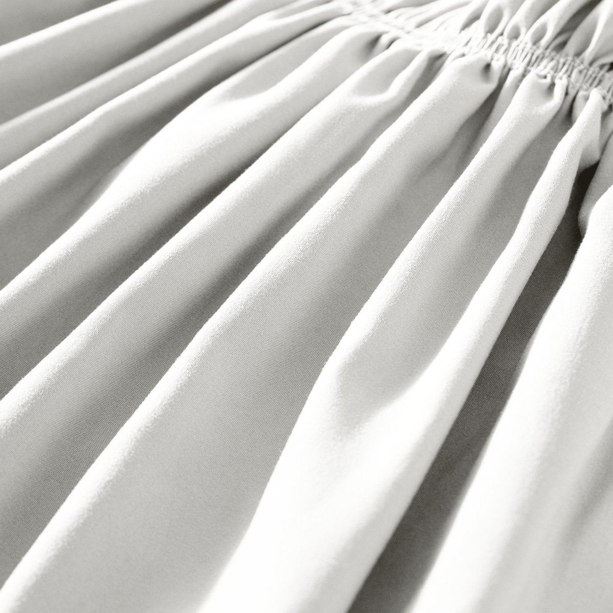 Close-up of polyester bed skirt fabric with a focus on texture and folds.