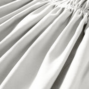 Close-up of polyester bed skirt fabric with a focus on texture and folds.