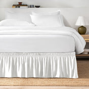 Bed with white bedding and a bed skirt.