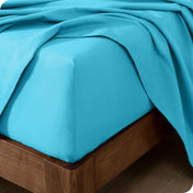 Close up of the corner of a mattress with a flannel fitted sheet and flat sheet on it