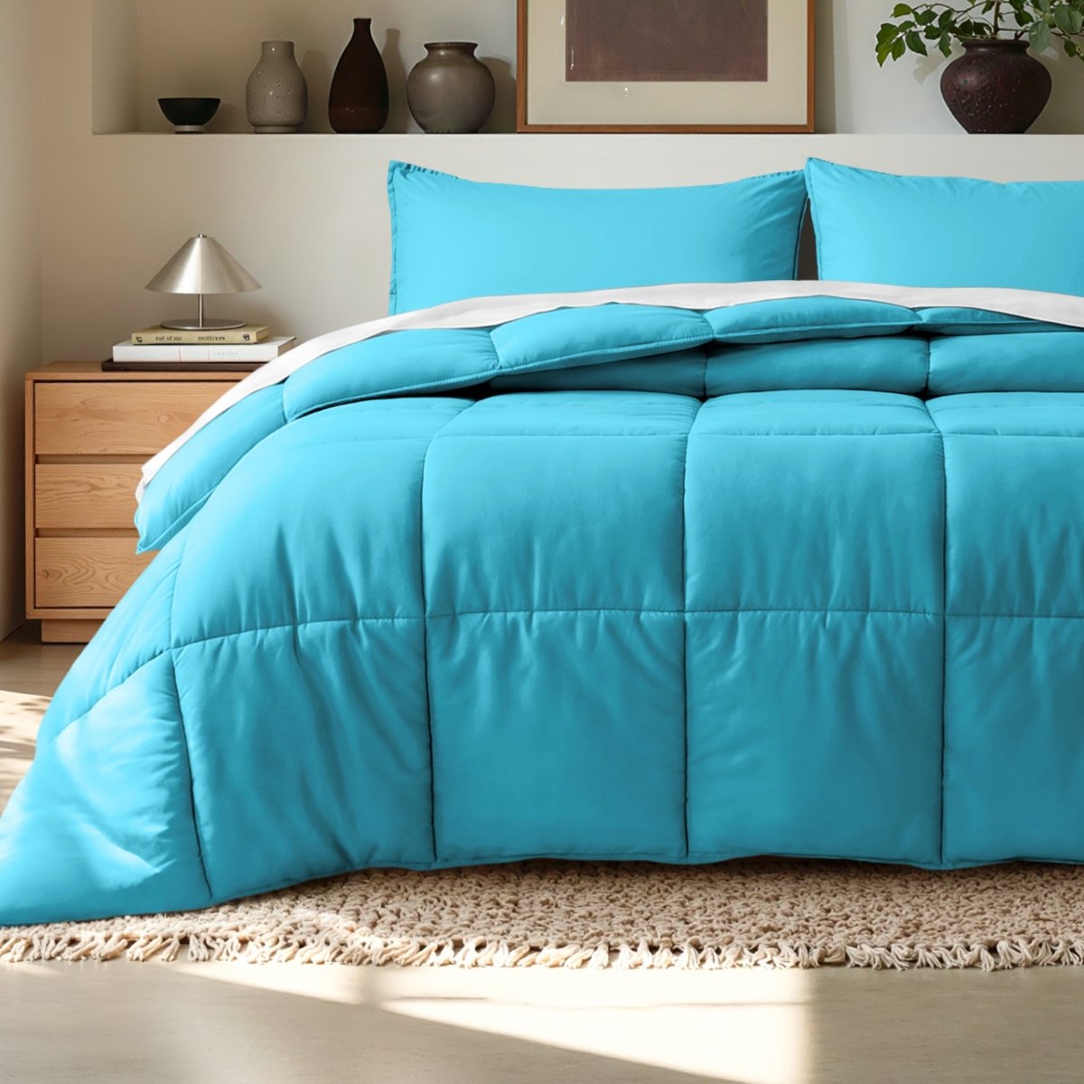Comforter on a bed in a bedroom setting with a wooden nightstand and decorative items.
