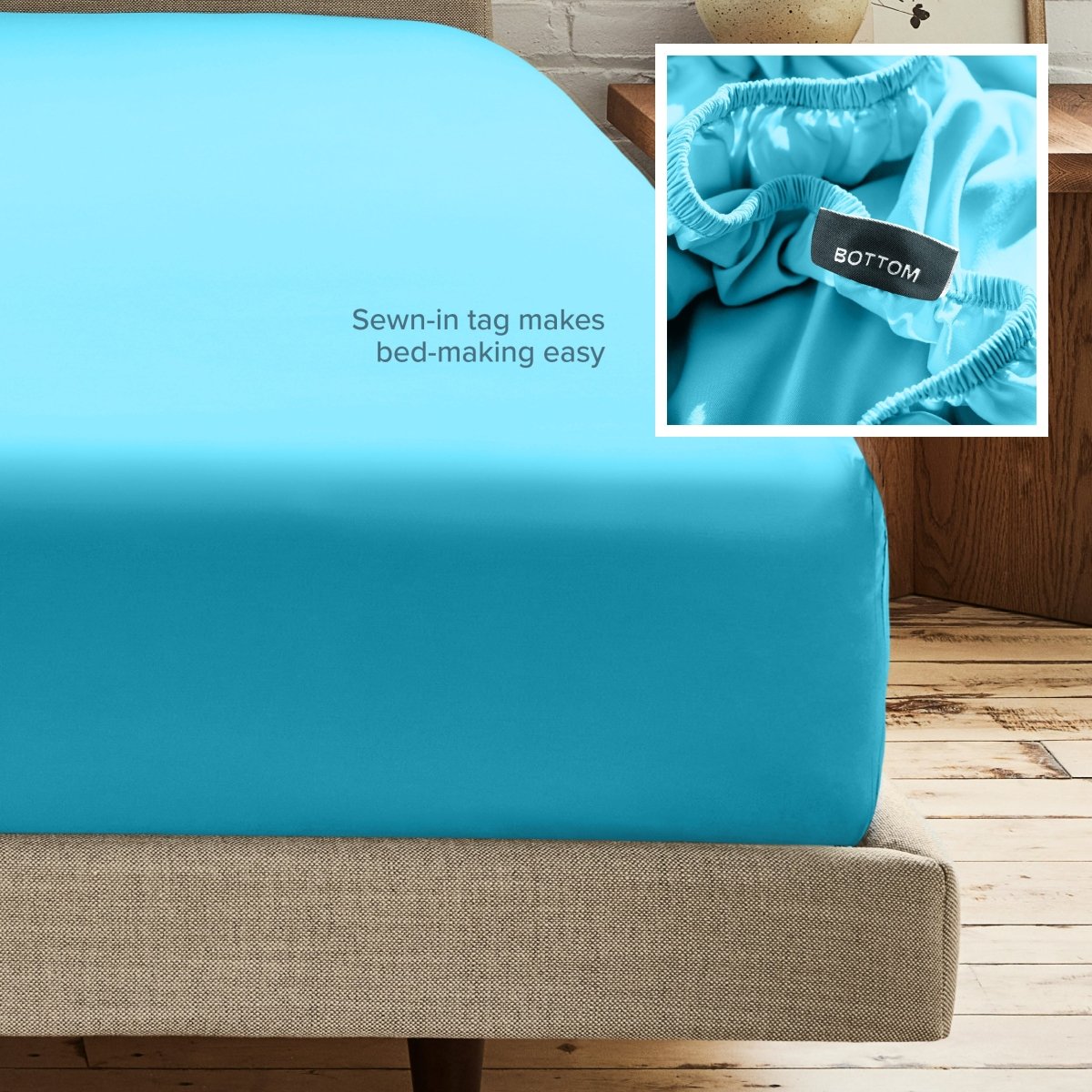 A fitted bed sheet on a bed frame with a small inset close-up of the elastic and a sewn-in tag labeled BOTTOM. White text on the sheet reads, 'Sewn-in tag makes bed-making easy.