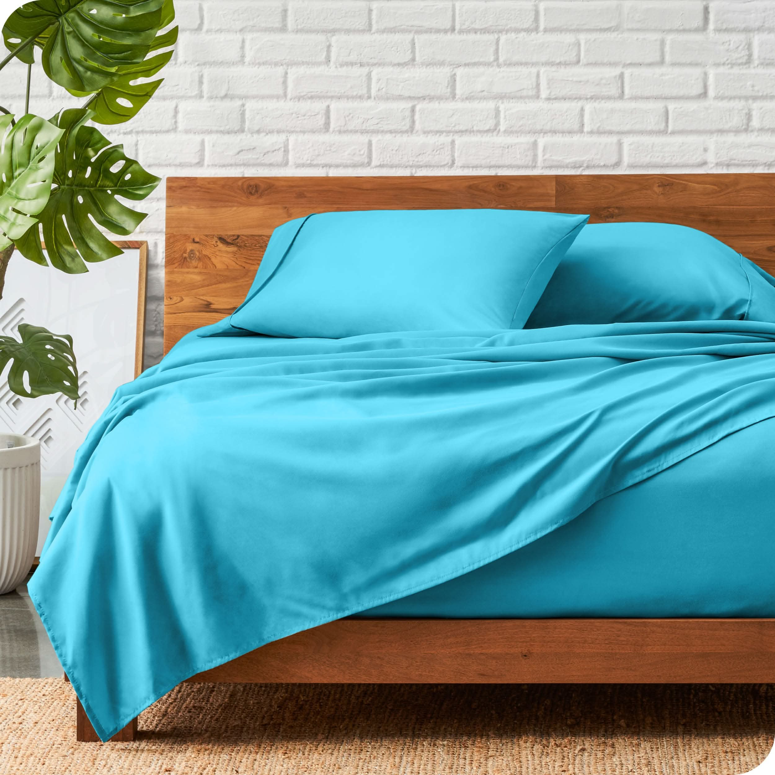 A wooden bed frame with a microfiber sheet set on the mattress.