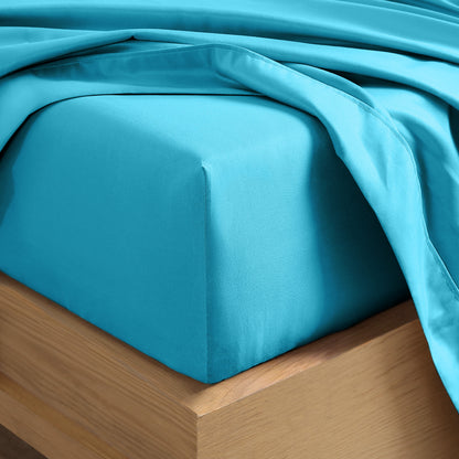 Close up of the corner of a mattress with a fitted sheet and flat sheet on it