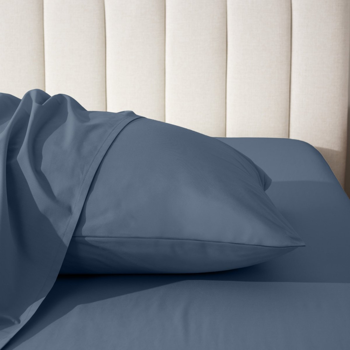 Pillow on a bed with a neutral headboard