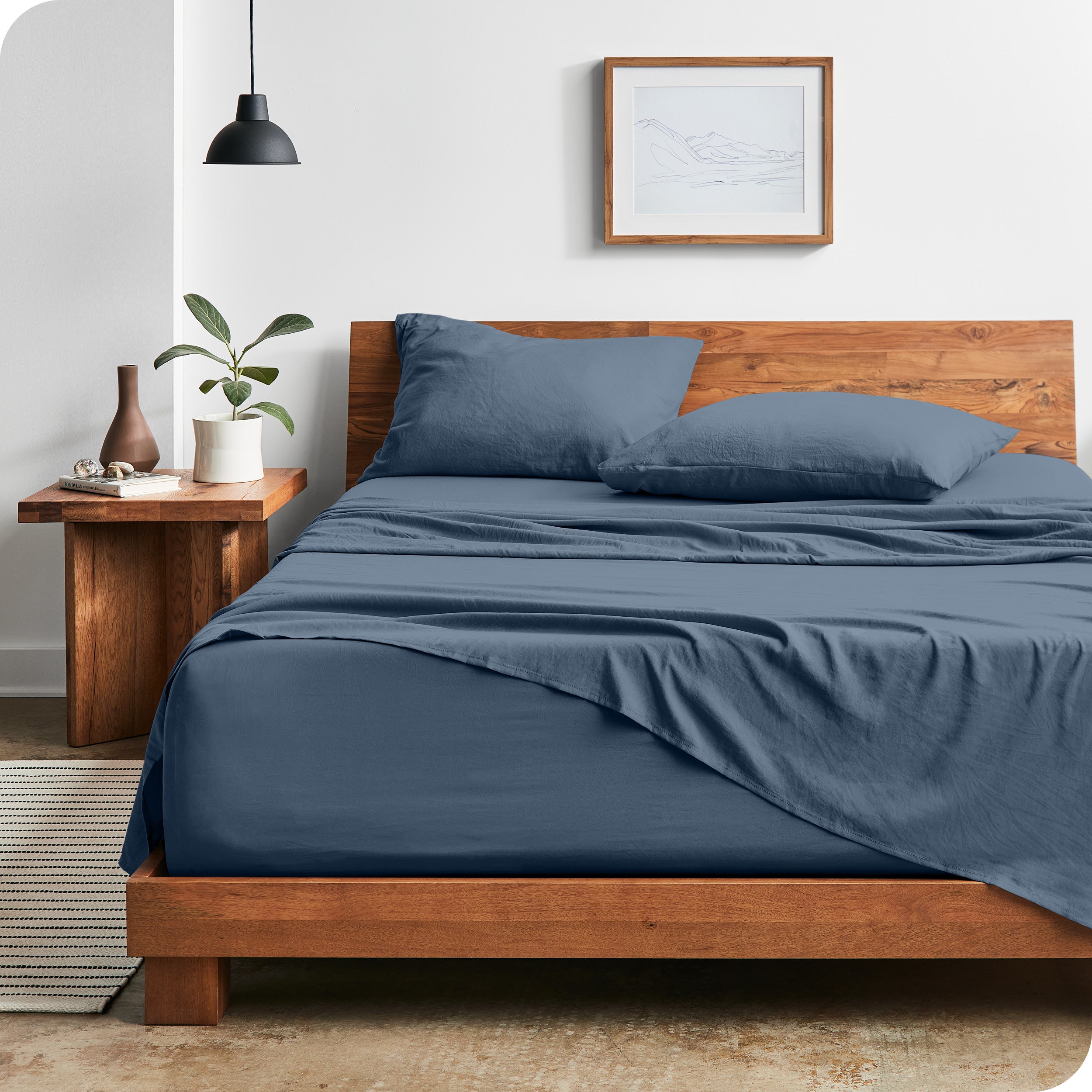 Modern bedroom with sandwashed sheets draped over the end and the side of the bed