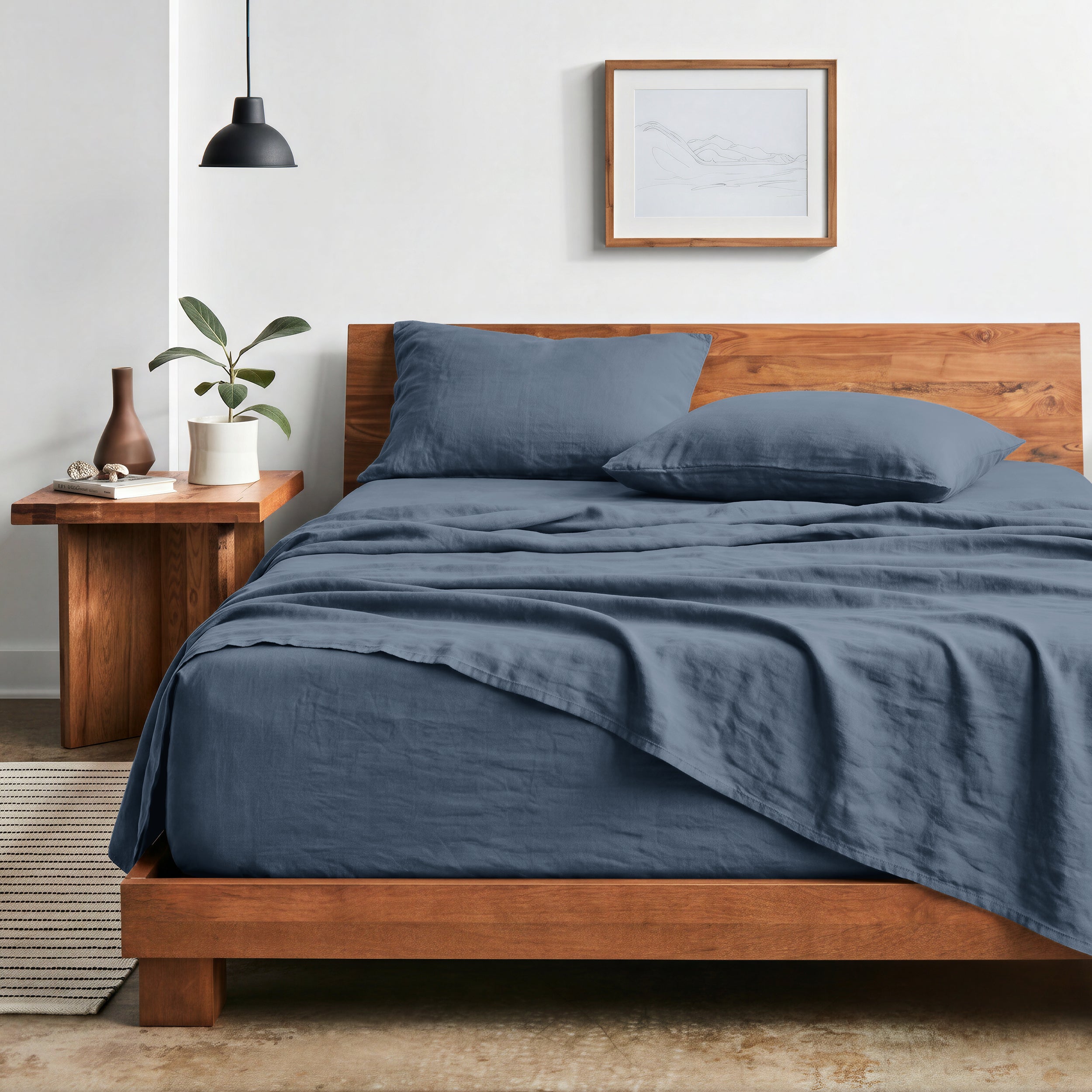 Bedroom with sheet set on a wooden bed frame and side table