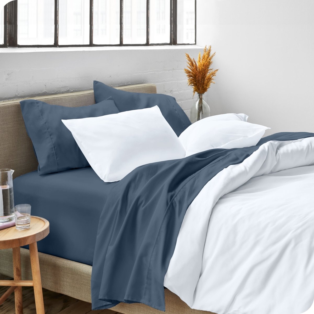 A side view of a bed made with microfiber sheets and a white duvet cover