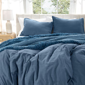 Bedding set on a bed with pillows in a bright room