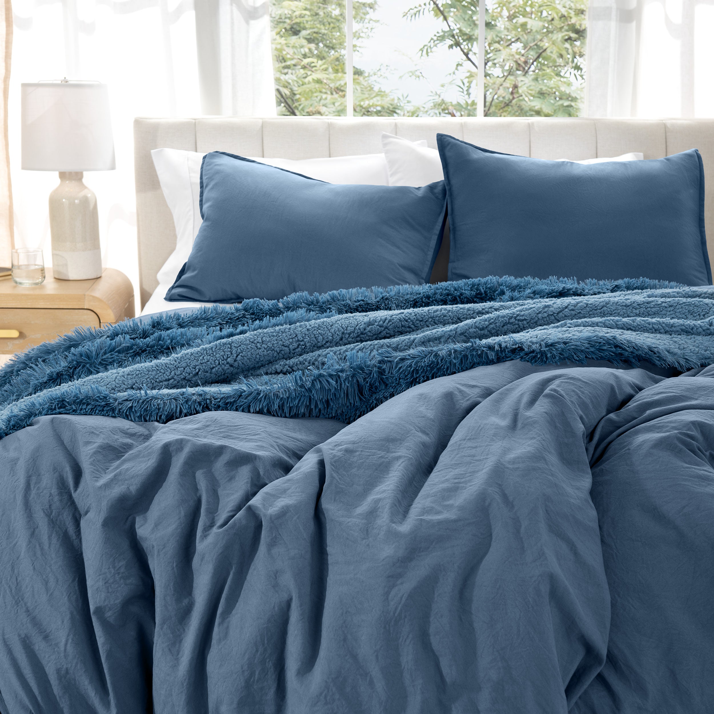 Bedding set on a bed with pillows in a bright room