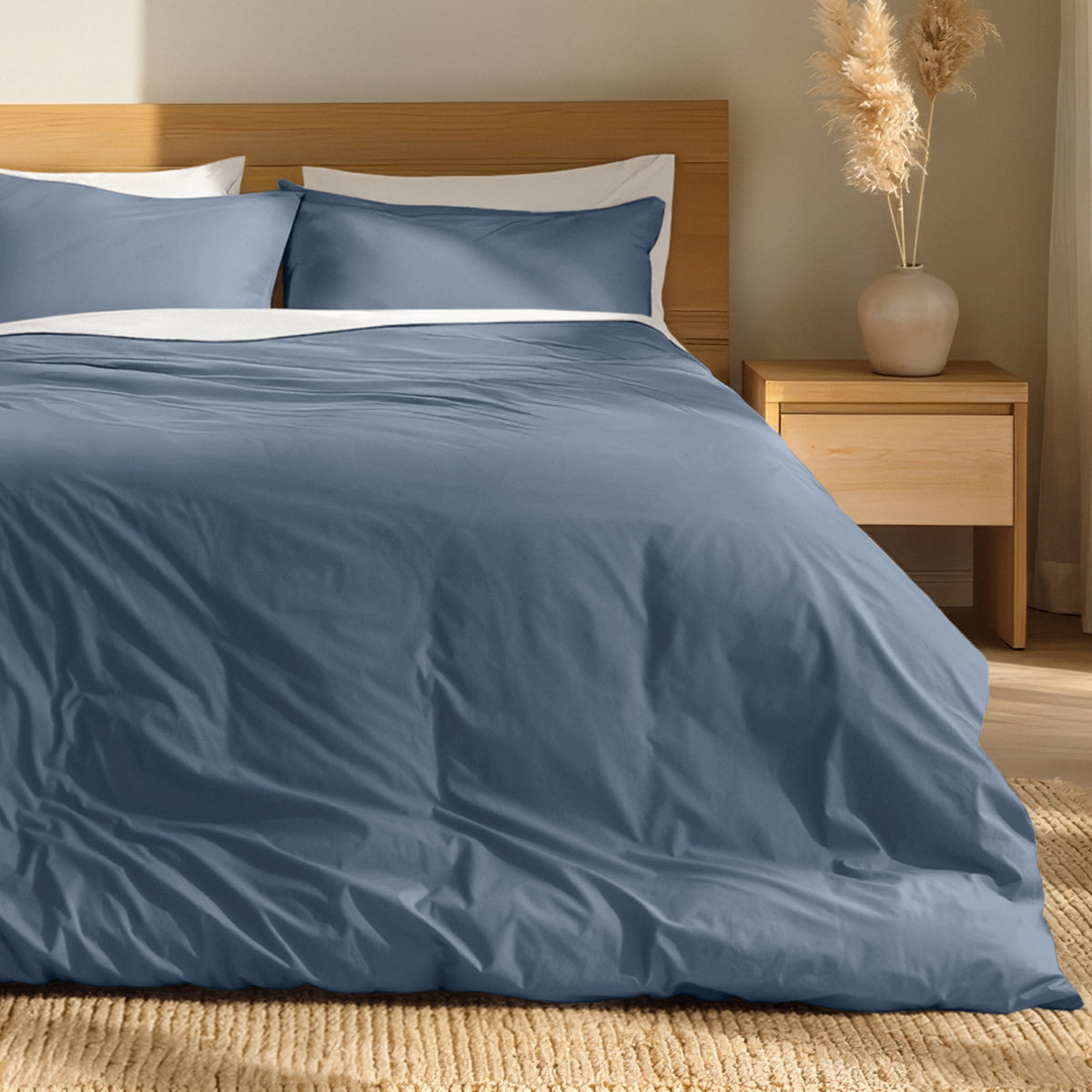 Percale bedding set on a bed with a wooden headboard and nightstand in a bedroom setting.