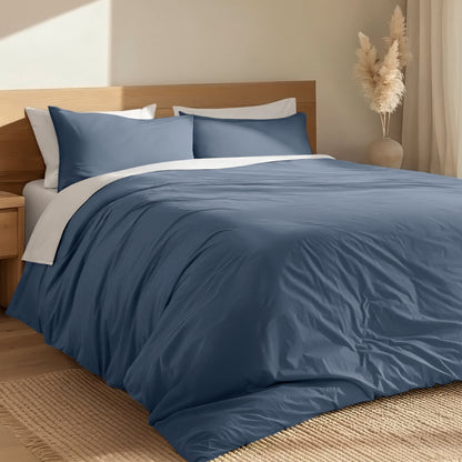 Bed with percale duvet cover set and wooden headboard in a room with a vase and decorative items.