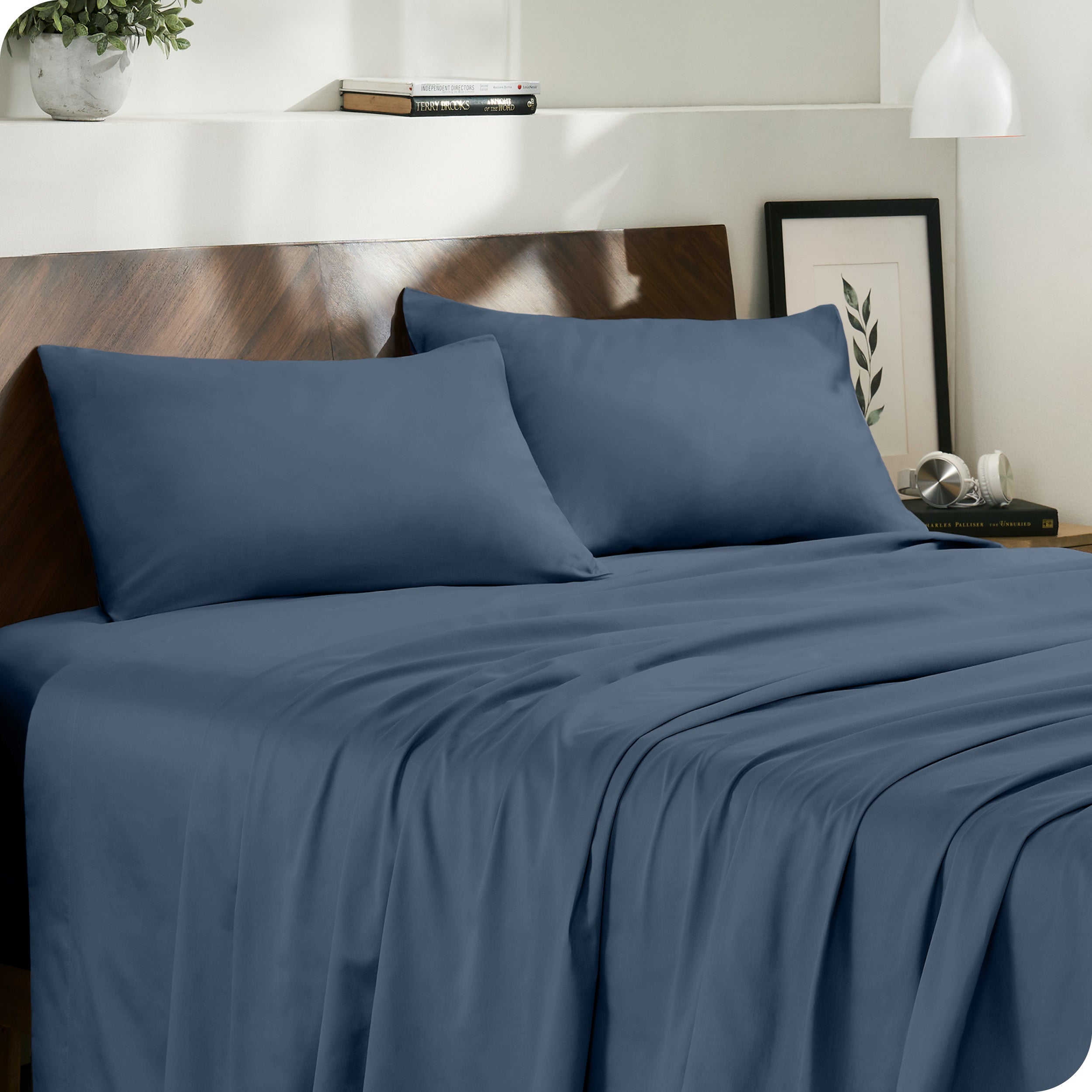 Diagonal view of modern bedroom with sateen sheets and pillowcases on the bed