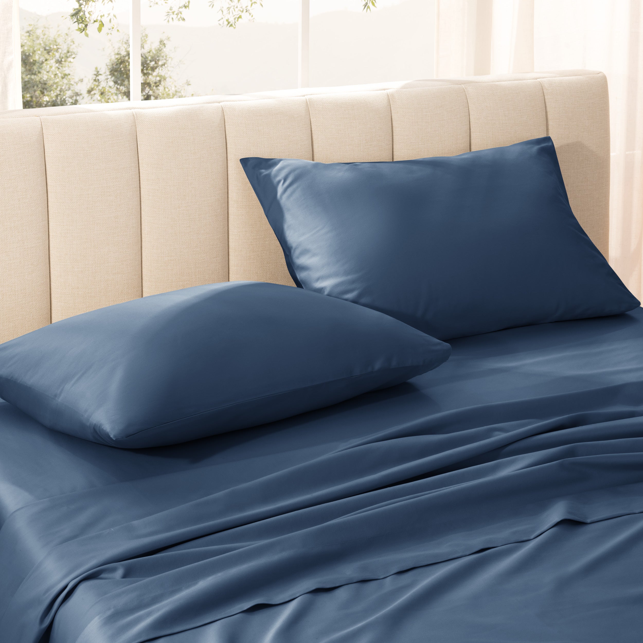 Sateen bedding set on a bed with a beige headboard.