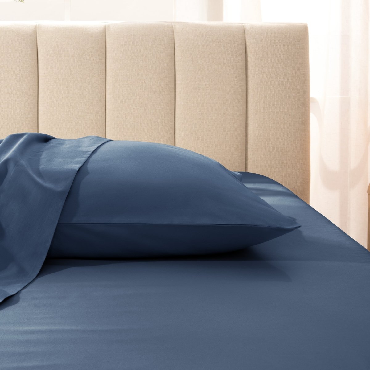 Sateen pillowcase on a bed with a beige headboard