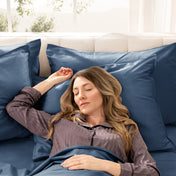 Woman sleeping peacefully in a bed made with sateen sheets and pillowcases.