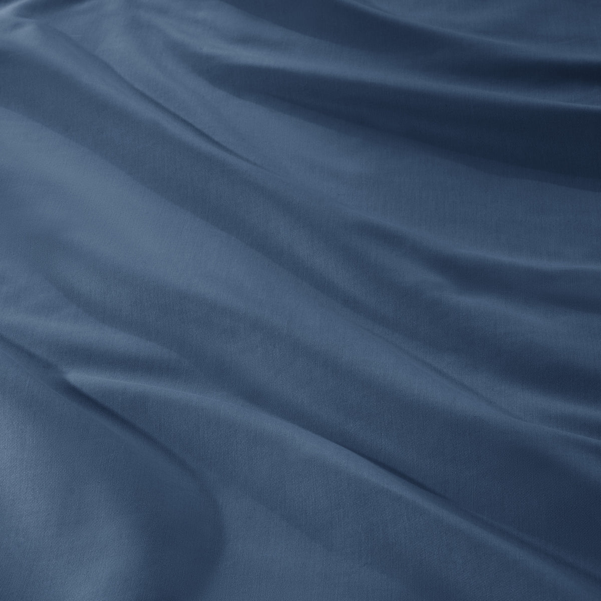 A close-up of draped sateen fabric with soft folds and a smooth texture.