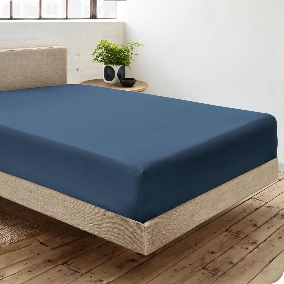 Diagonal view of room scene with percale fitted sheet on the bed