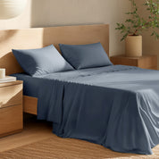 Bed with percale bedding and wooden headboard in a bedroom setting