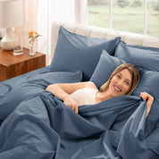 Woman lying in bed with percale bedding in a bright bedroom