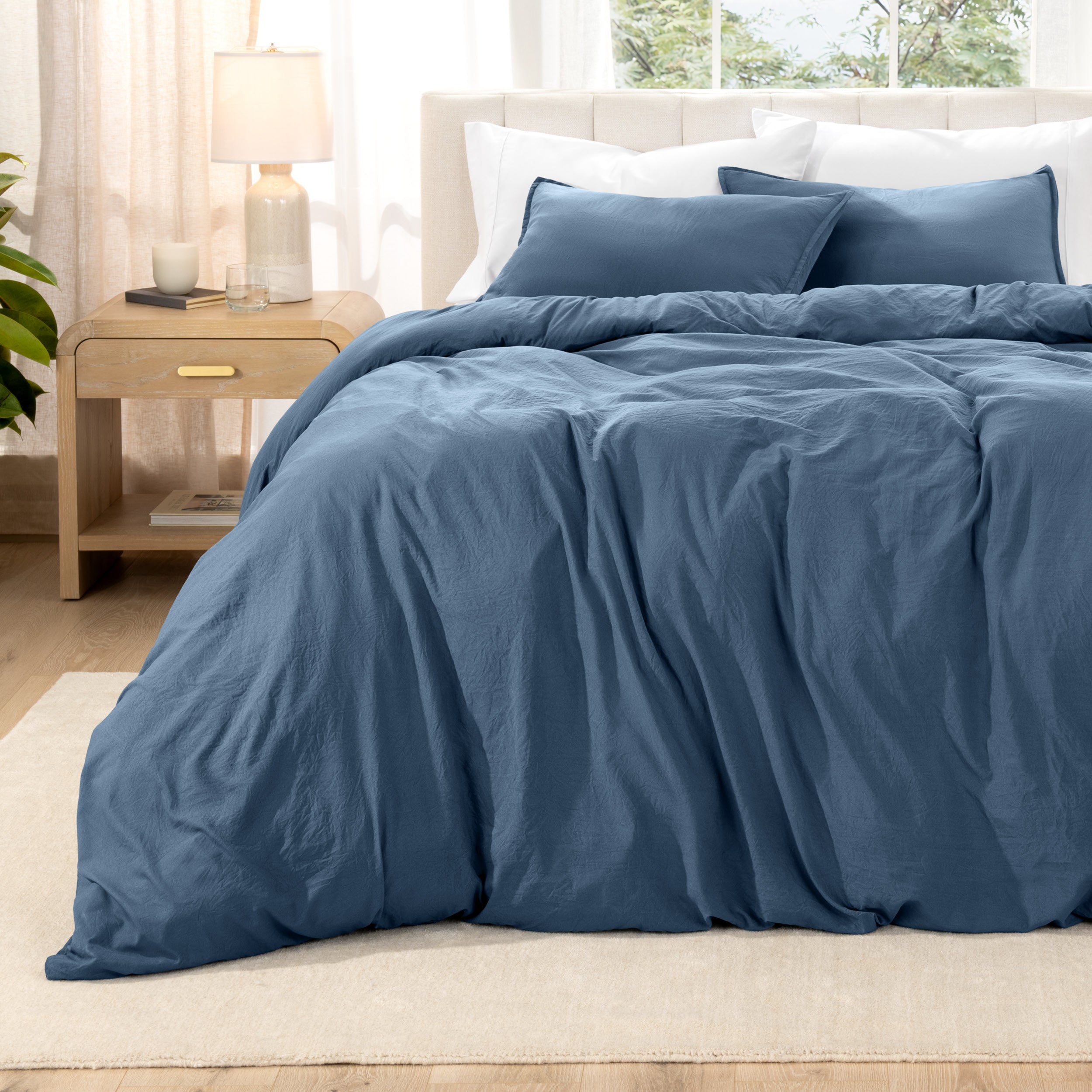 Washed bedding set on a bed with a nightstand in the background