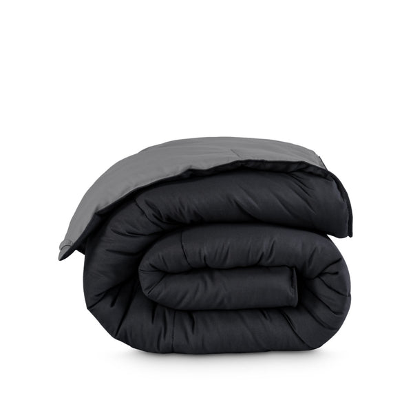 Folded reversible comforter on a white background
