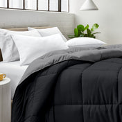 Bed with comforter and white pillows in a bright bedroom setting.