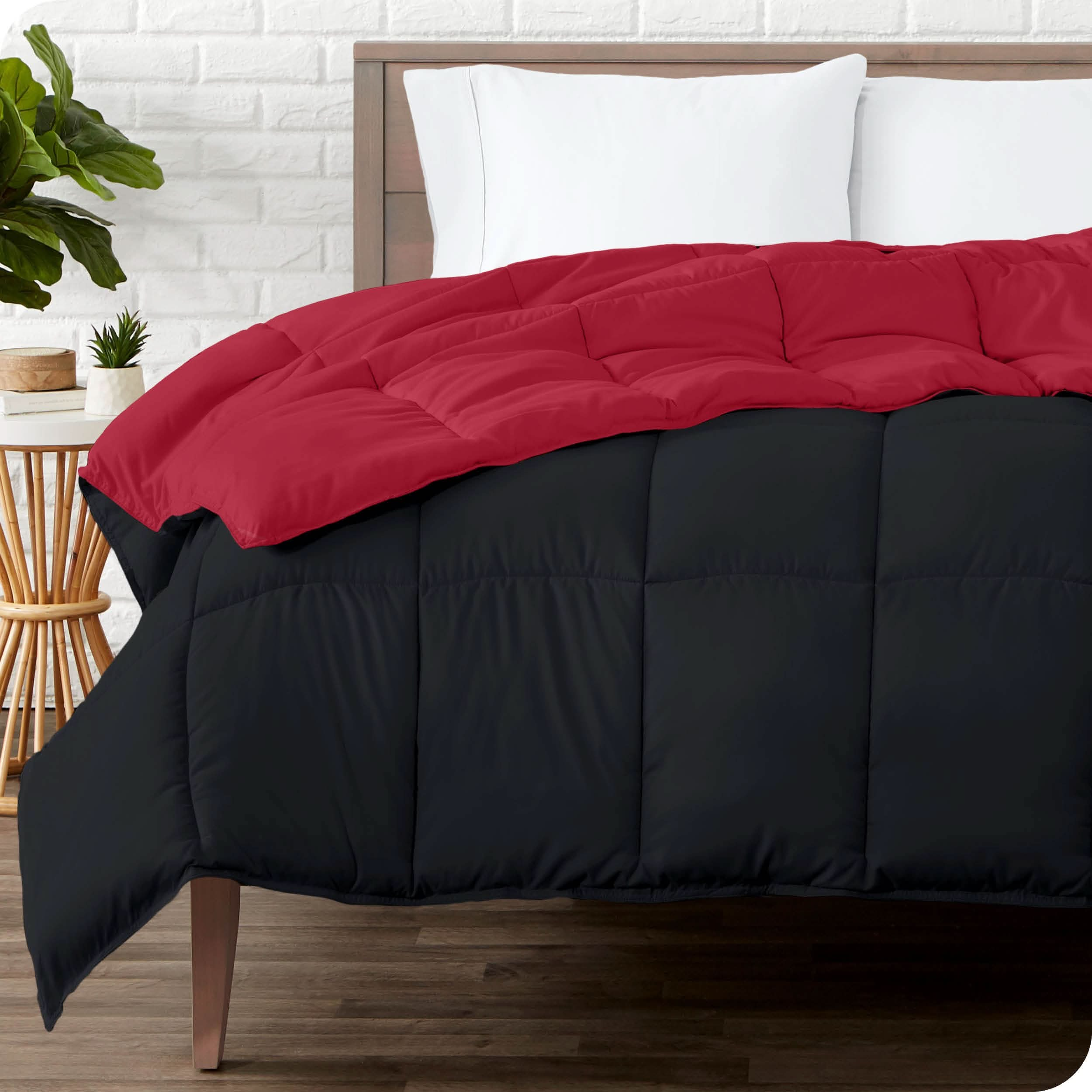 Wooden bed frame with a reversible comforter on the mattress. The comforter is folded back showing the two different colored sides.