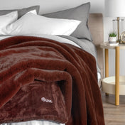 Blanket with 'Bare' branding on a bed in a bedroom setting