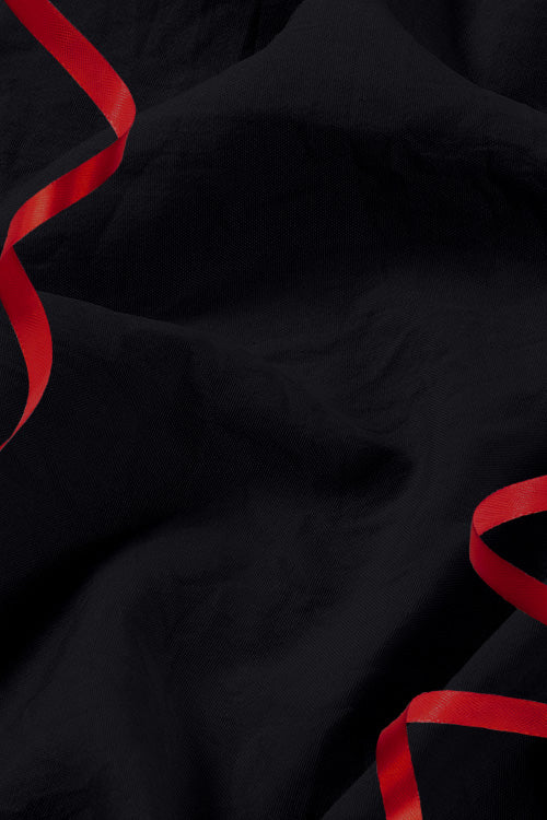 Black fabric with red ribbons on a dark background for Black Friday 