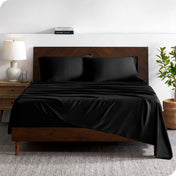 A contemporary bed with a sheet set and a wooden headboard.