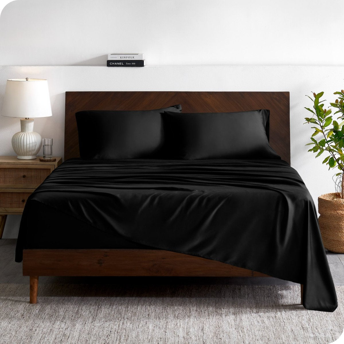 A contemporary bed with a sheet set and a wooden headboard.