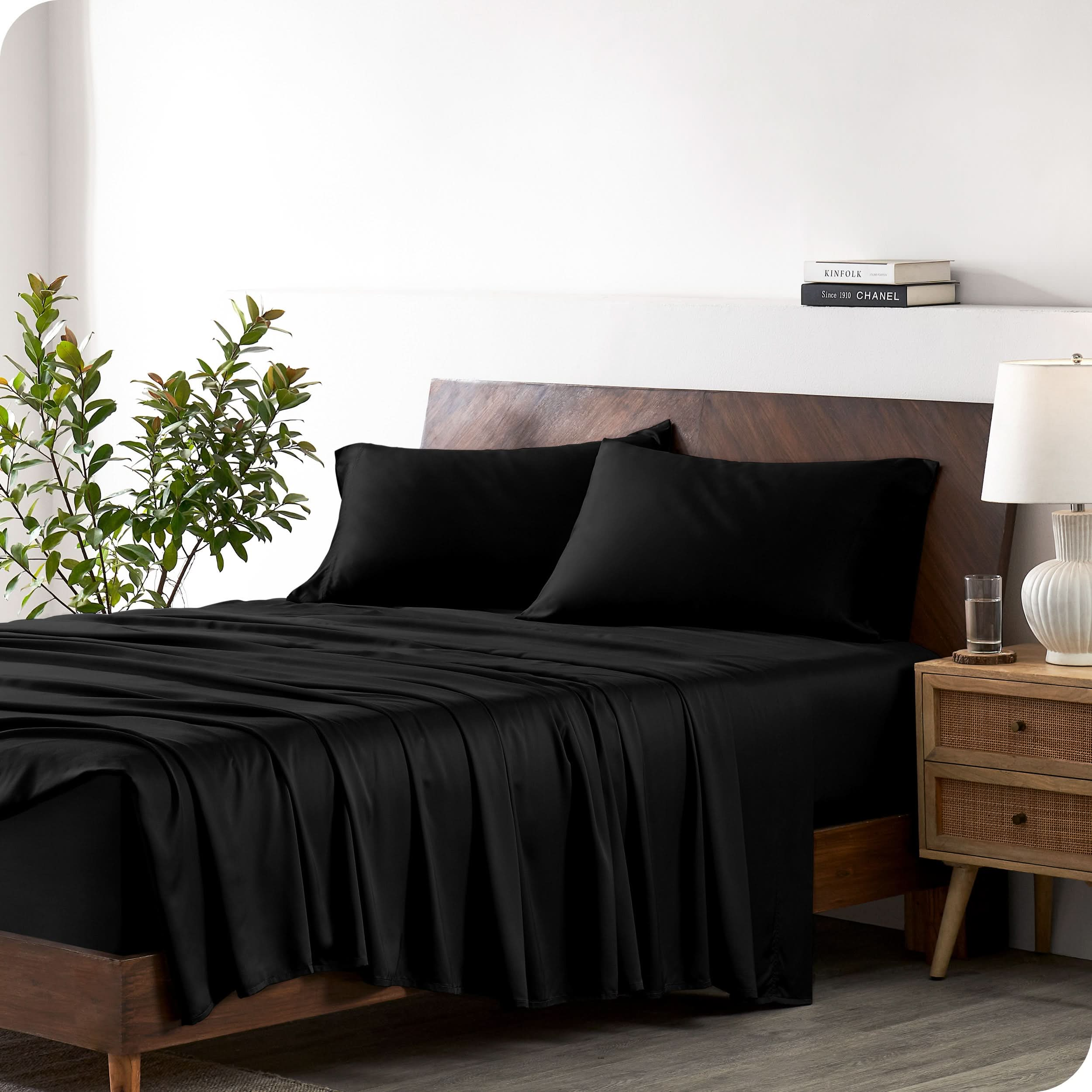 A bamboo sheet set draped over a bed with a wooden bed frame