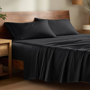 Bamboo bed sheets on a bed in a bedroom with night stands.