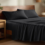 Bamboo bed sheets on a bed in a bedroom with night stands.
