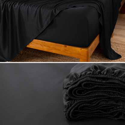 A fitted sheet on a mattress with wooden bed frame and folded on a dark surface